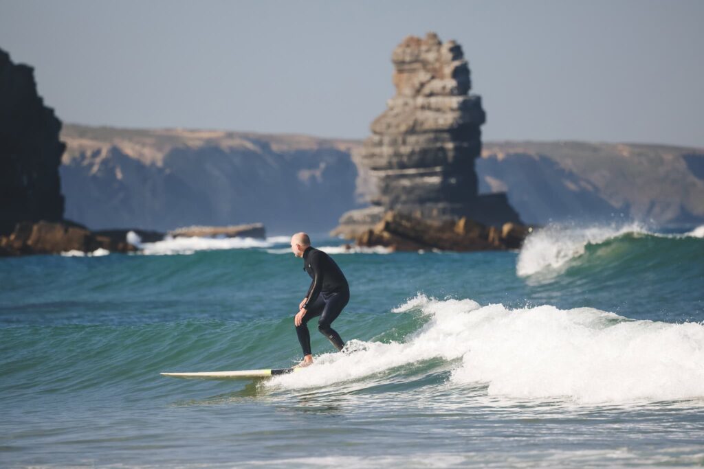 A surfer in arrifana beach located in southwest portugal aljezur