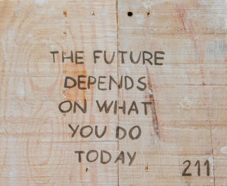 Quote on a wooden board saying: The future depends on what you do today