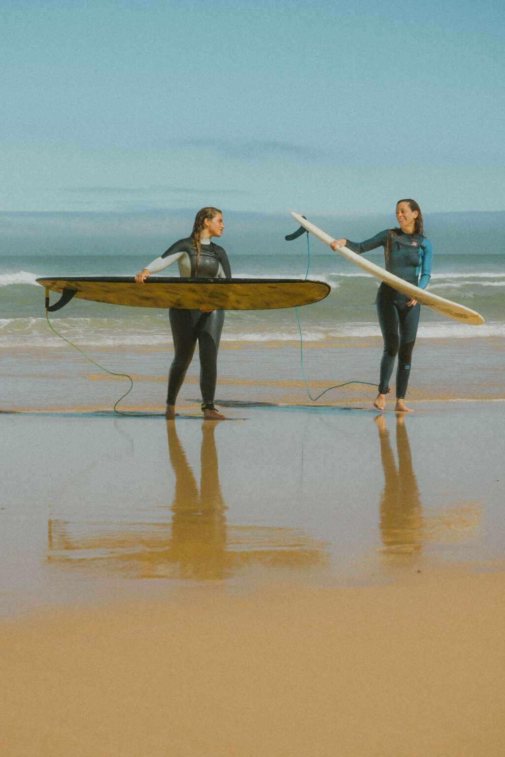 two longboarders chatting on the beach of Monte Clerigo in Southwest Alentejo, Aljezur, Portugal